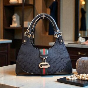 Gucci black GG canvas and leather Web hobo bag with a piston lock closure